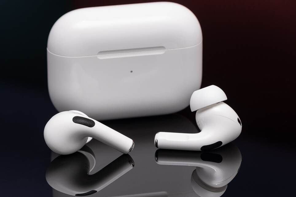 AirPods Pro thế hệ thứ hai của Apple được chụp ảnh trên bề mặt màu đen phản chiếu.