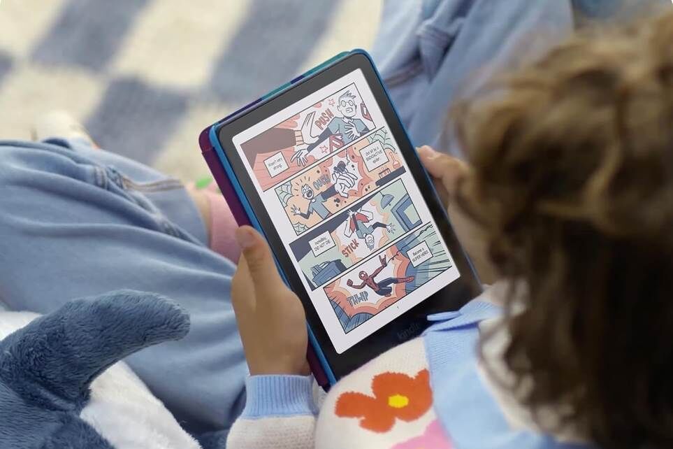Một đứa trẻ đang cầm một máy đọc sách điện tử Kindle Colorsoft màu có màn hình bật.