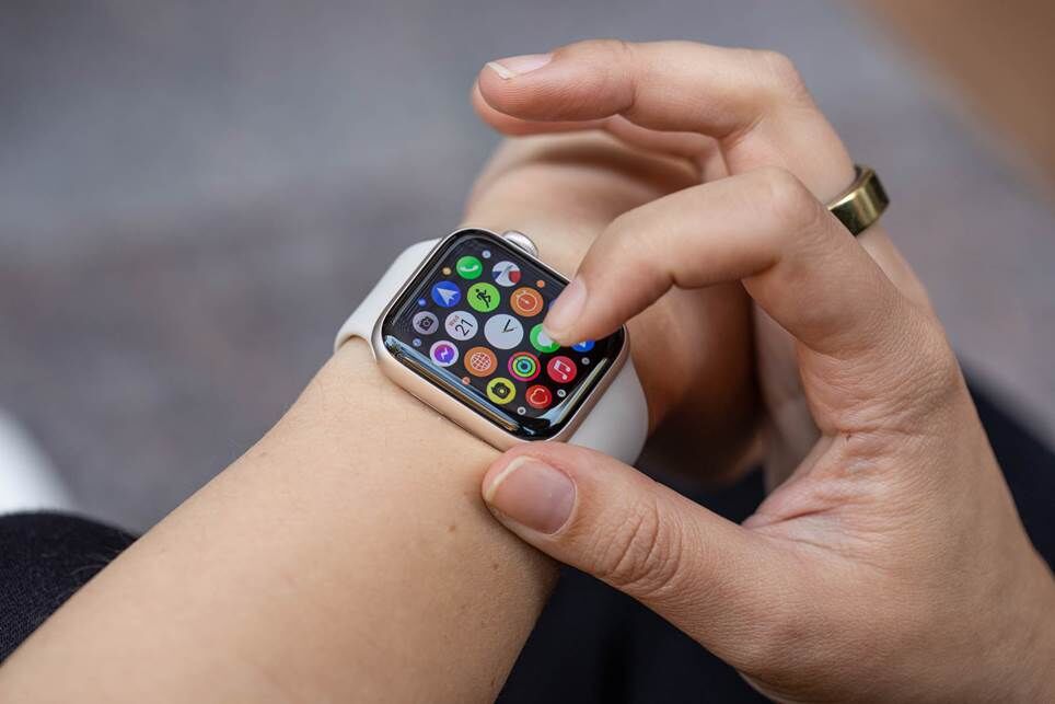 Người phụ nữ đang nhìn vào lưới ứng dụng trên Apple Watch SE (2022).