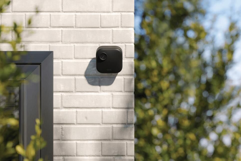 Một chiếc camera không dây màu đen gắn trên tường.