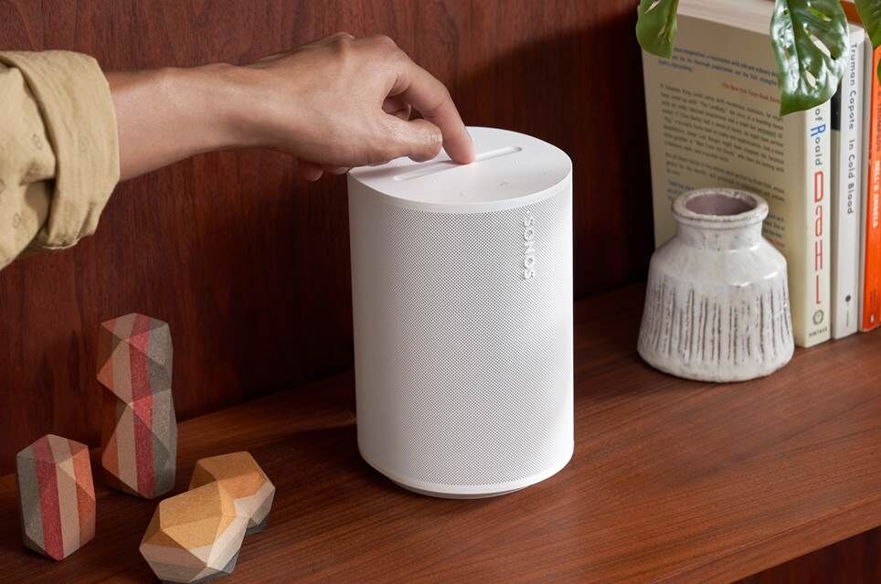Hình ảnh tiếp thị loa Sonos Era 100 trên kệ gỗ.