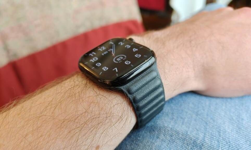 Chiếc Apple Watch Series 10, có dây đeo bằng da, trên cổ tay của một ai đó.