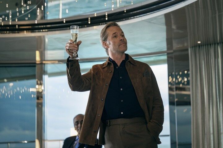 A man holds up a glass of champagne.